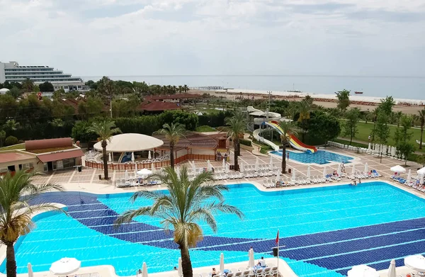 Weergave van het blauwe zwembad en het strand in een Turkse hotel. — Stockfoto