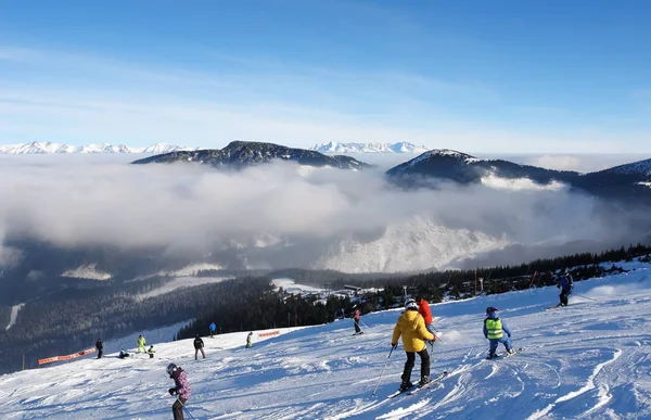 Skiërs op de skipiste op een zonnige dag in het resort van Jasna. — Stockfoto