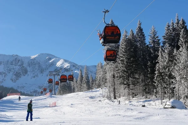 Funivia e sciatori in una giornata di sole sulle piste della stazione sciistica — Foto Stock