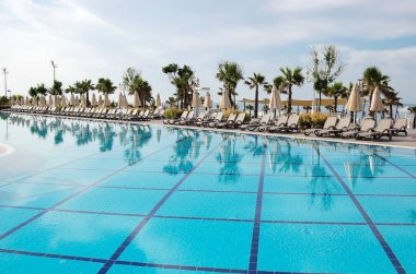 Türk lüks otel mavi Havuzu, şemsiye ve güneş yataklarda görünümünü.
