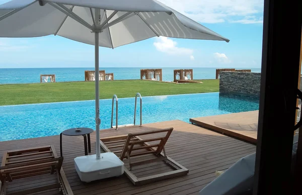 Uitzicht vanaf het terras naar het zwembad en het strand met stijlvolle tenten in een eersteklas hotel in Turkije. — Stockfoto