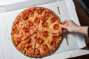 Pizza salam ve peynir. Elinde bir dilim pizza