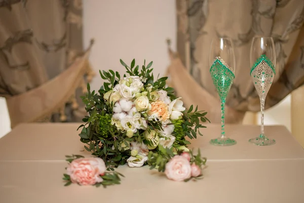 Ramo de la novia con ramas de pistacho, ramas de algodón y rosas blancas y dos flautas de champán pintadas a mano. Concepto de boda — Foto de Stock