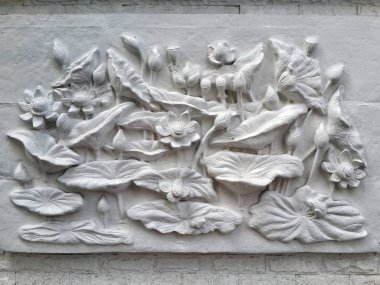 Wall bas-relief stucco in plaster, depicts Lotus flowers. Bangkok, Thailand clipart