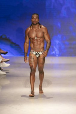 Sanat, Kalpler ve Moda Yüzüşü 2018 'de Miami Plajı' ndaki Faena Forumu 'nda 15 Temmuz 2018' de yapılan Bay Üçlü X Moda Şovu Yaz 2019 koleksiyonunda bir model podyumda yürüyor.