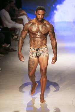 Sanat, Kalpler ve Moda Yüzüşü 2018 'de Miami Plajı' ndaki Faena Forumu 'nda 15 Temmuz 2018' de yapılan Bay Üçlü X Moda Şovu Yaz 2019 koleksiyonunda bir model podyumda yürüyor.