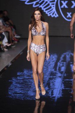 Sanat, Kalpler ve Moda Yüzüşü 2018 'de Miami Plajı' ndaki Faena Forumu 'nda 15 Temmuz 2019' da yapılan Bay Üçlü X Moda Şovu Yaz 2019 koleksiyonunda bir model podyumda yürüyor.
