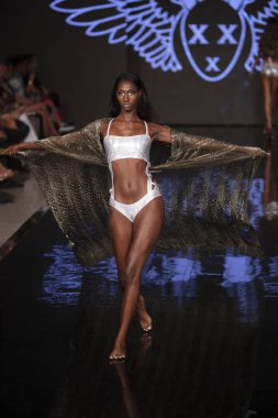 Sanat, Kalpler ve Moda Yüzüşü 2018 'de Miami Plajı' ndaki Faena Forumu 'nda 15 Temmuz 2019' da yapılan Bay Üçlü X Moda Şovu Yaz 2019 koleksiyonunda bir model podyumda yürüyor.