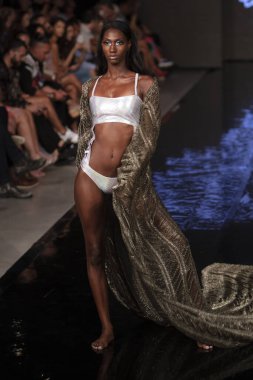 Sanat, Kalpler ve Moda Yüzüşü 2018 'de Miami Plajı' ndaki Faena Forumu 'nda 15 Temmuz 2019' da yapılan Bay Üçlü X Moda Şovu Yaz 2019 koleksiyonunda bir model podyumda yürüyor.