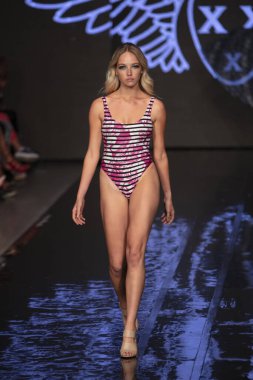 Sanat, Kalpler ve Moda Yüzüşü 2018 'de Miami Plajı' ndaki Faena Forumu 'nda 15 Temmuz 2019' da yapılan Bay Üçlü X Moda Şovu Yaz 2019 koleksiyonunda bir model podyumda yürüyor.