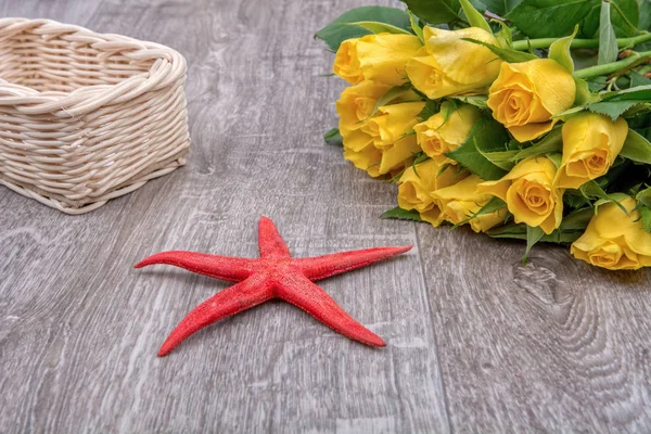 Estrella de mar roja y rosas sobre fondo de madera — Foto de Stock