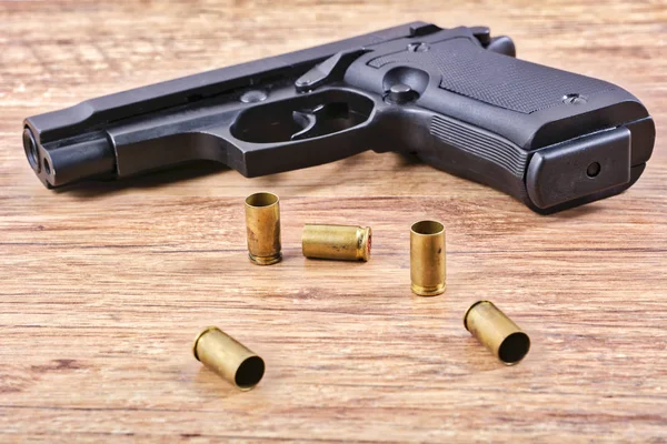 Bir tabloda boş kartuşlar ile tabanca