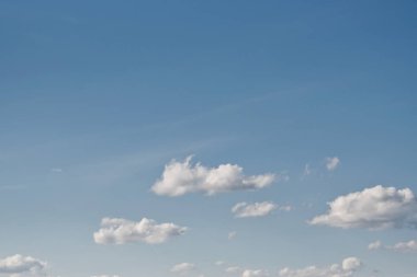 Metin arkaplanı için alanı olan düz beyaz bulutlu açık mavi gökyüzü. 