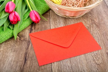 Lale ahşap bir masa üzerinde kırmızı zarf