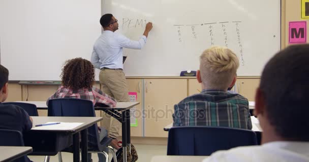 Schoolmeisje schriftelijk op whiteboard vooraan klasse — Stockvideo