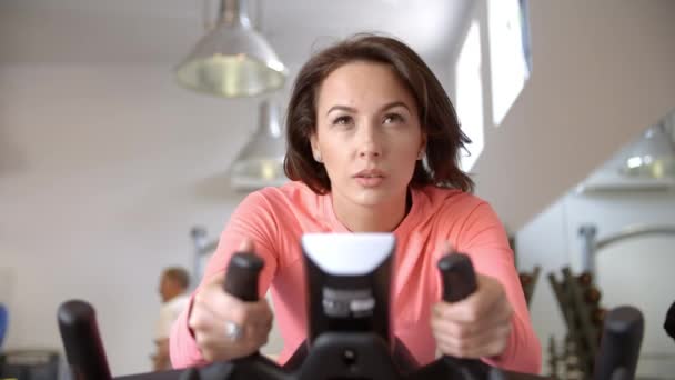 在健身房锻炼自行车的女人 — 图库视频影像