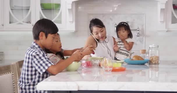 Rušné matka uspořádání dětí u snídaně — Stock video