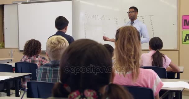 Estudante escrevendo em quadro branco na classe de frente — Vídeo de Stock