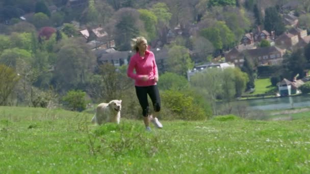 Жінка з собакою бігу — стокове відео