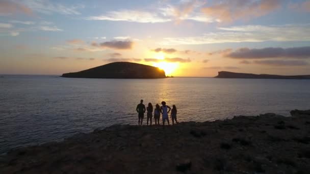 Przyjaciele na klifach, oglądając zachód słońca nad morzem — Wideo stockowe