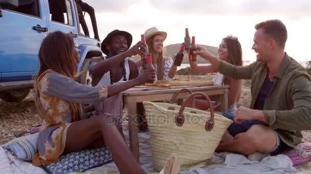 Друзі насолоджуються пікнік на скелях морем — стокове відео
