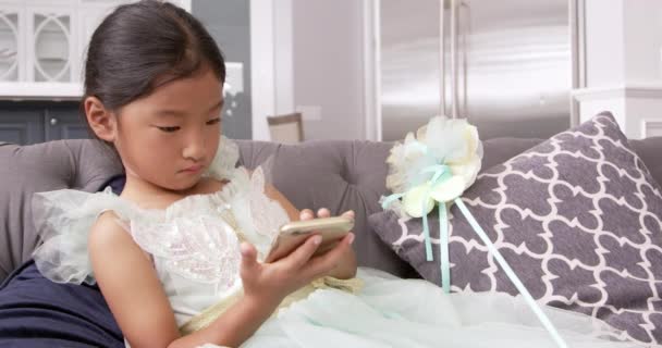 Menina jogando jogo no dispositivo móvel — Vídeo de Stock