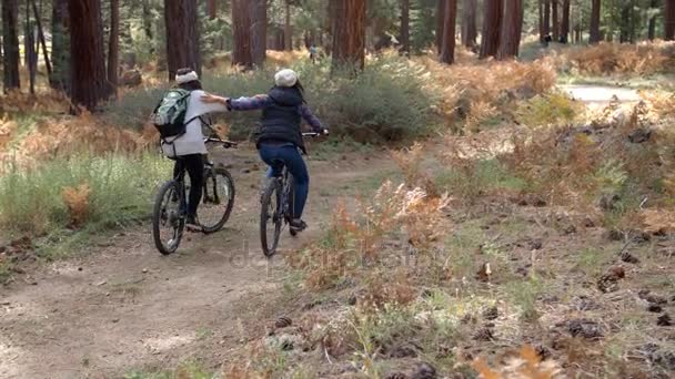 Женщины обнимаются, катаясь на велосипеде — стоковое видео