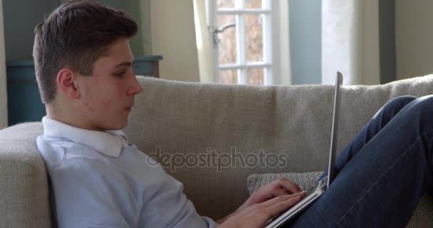 Εφηβικό αγόρι που χρησιμοποιεί φορητό υπολογιστή — Αρχείο Βίντεο