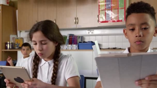 Ученики сидят за рабочими столами — стоковое видео