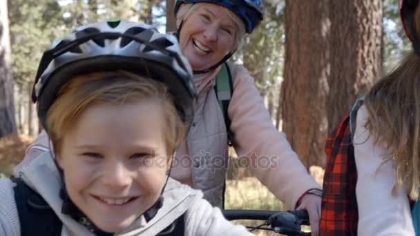 Дети и дедушка с бабушкой на велосипедах в лесу — стоковое видео