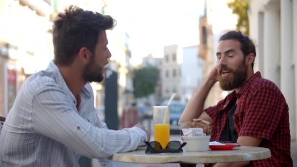 Zwei Freunde unterhalten sich an einem Tisch — Stockvideo