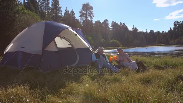 Senior couple sitting outside tent — Stock Video