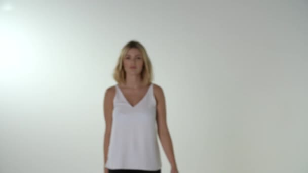 Unga blonda kvinnan promenader till kamera — Stockvideo