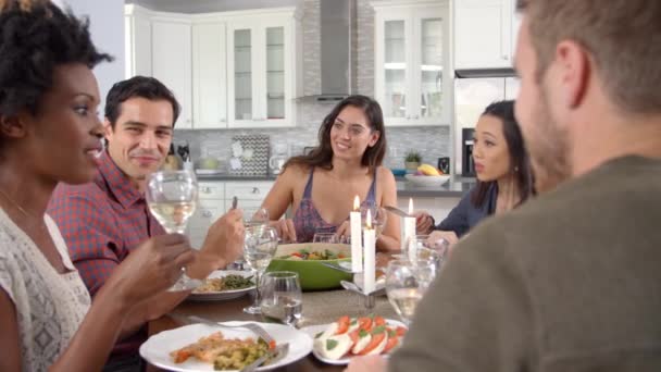 Amigos hablando y comiendo en una mesa — Vídeo de stock