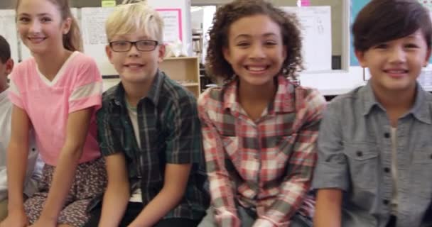 Grundskola barnen sitter i en rad — Stockvideo