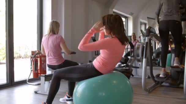Mujer haciendo crujidos en la pelota de fitness — Vídeos de Stock