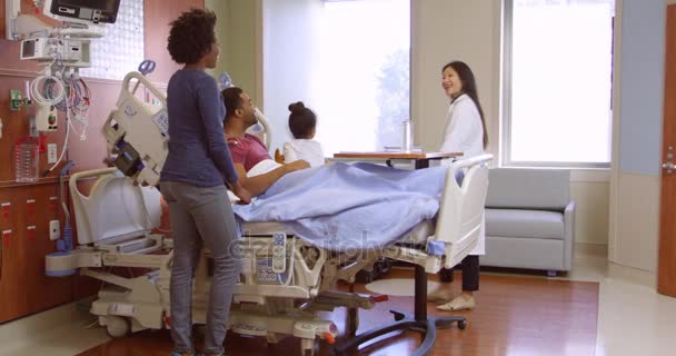 Médico visita paciente e família no hospital — Vídeo de Stock