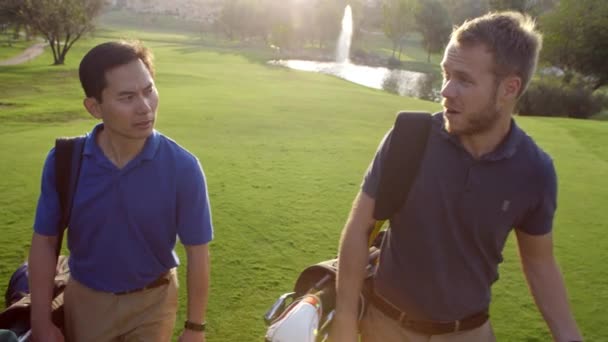 Мужчины-гольфисты идут по ярмарке — стоковое видео