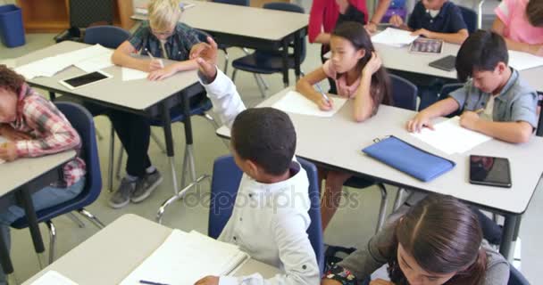 Учитель помогает школьнику в классе — стоковое видео