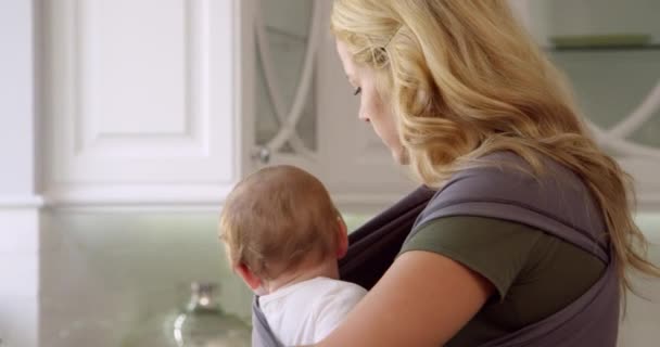 Rušnou matka s dítětem v šátku — Stock video