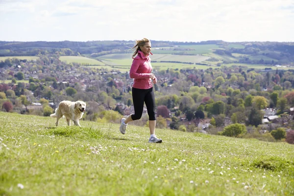 Frau mit Golden Retriever joggt — Stockfoto