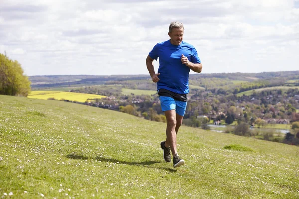 Volwassen Man joggen op platteland — Stockfoto