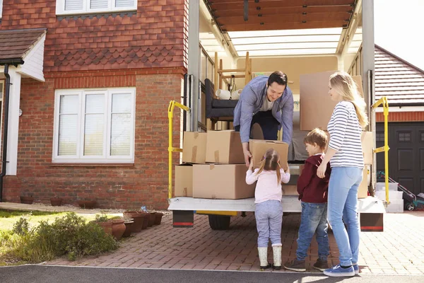 Семья перевозит коробки из грузовика — стоковое фото