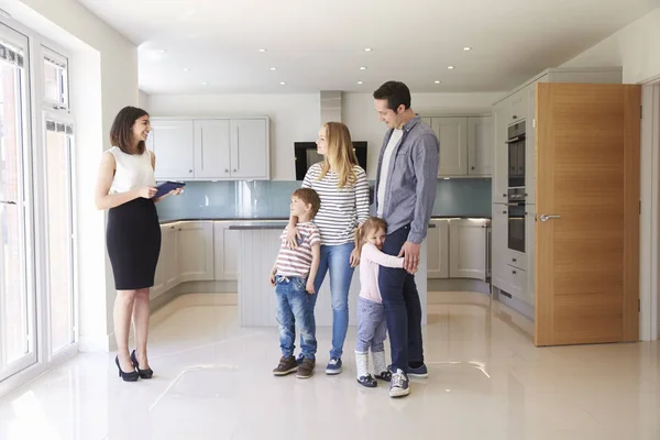 Realtor mostrando família em torno da propriedade para venda — Fotografia de Stock