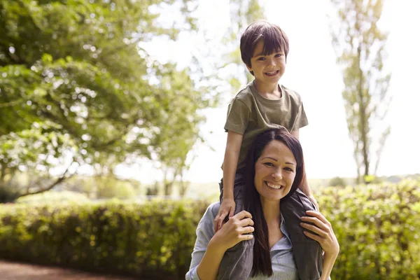 Madre giving figlio cavalcare su spalle — Foto Stock