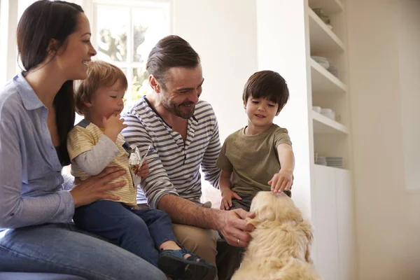 Familie sitzt mit Golden Retriever — Stockfoto