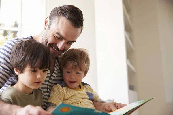 Отец и сыновья читают историю — стоковое фото