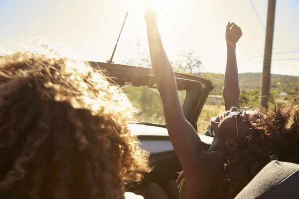 Jeune couple en voiture à toit ouvert — Photo