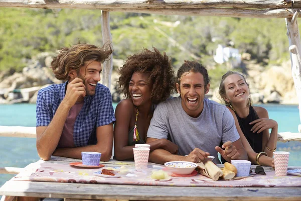 Quatro amigos à mesa à beira-mar — Fotografia de Stock