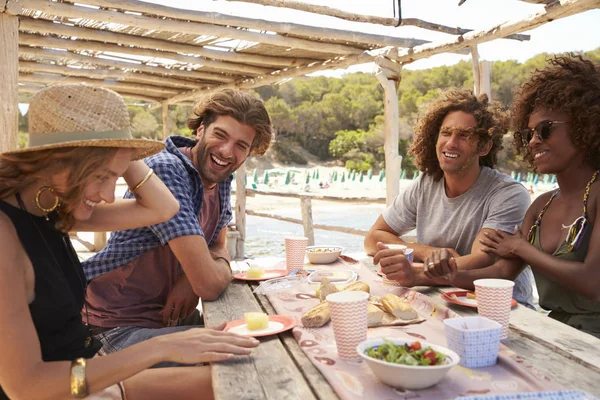 Vänner som pratar på ett bord vid havet — Stockfoto